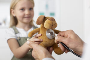 Criança segurando ursinho de pelúcia e profissional da saúde com um estetoscópio no ursinho. ecocardiograma infantil